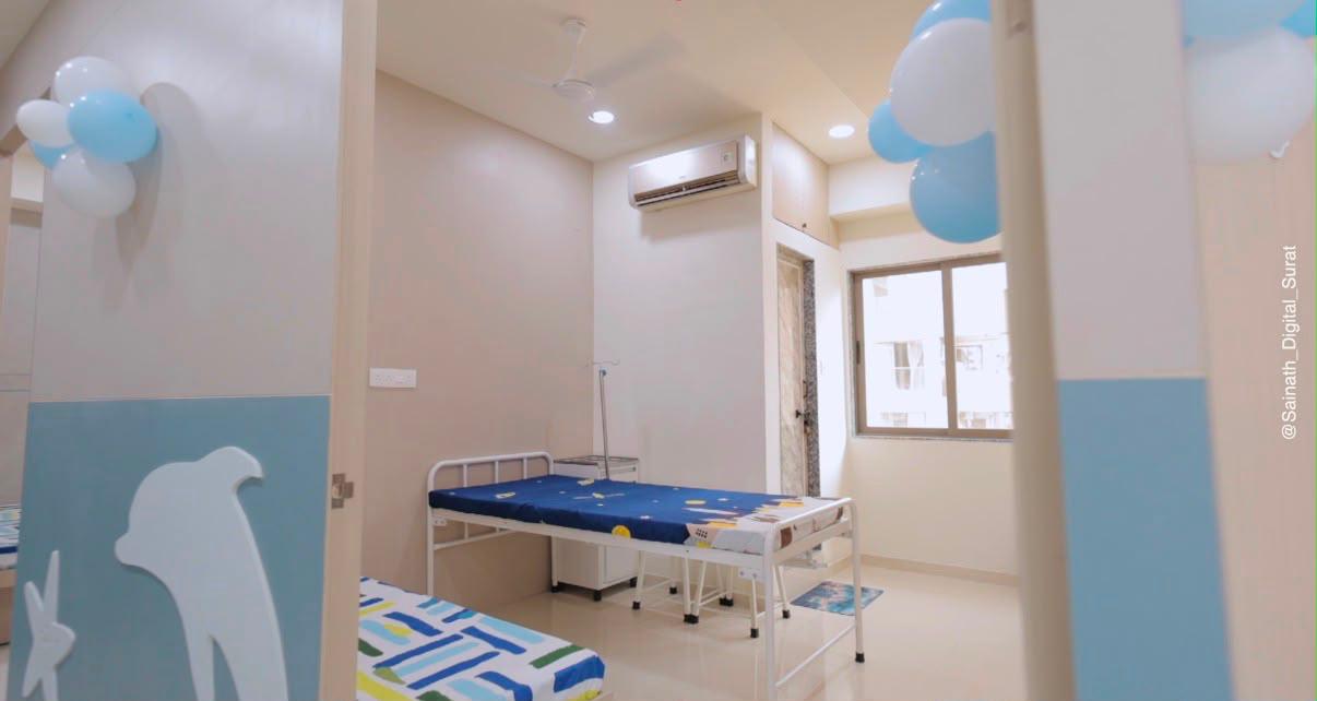 Bright pediatric patient room with balloons and dolphin decor